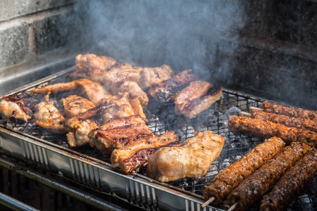 Variety of meat are cooked on a disposable BBQ setの写真素材