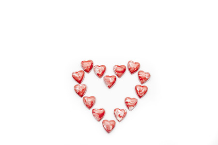 Red and white heart shaped chocolates arranged in heart on white background directly from above copy spaceの写真素材