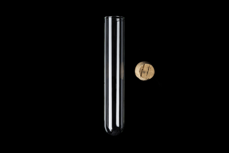 Glass transparent test tube with cork on side on black backgroundの写真素材