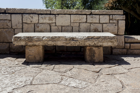 Stone white fence behind the stone bench on a stone ground outdoorsの写真素材