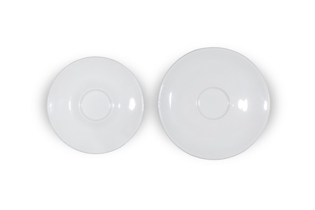 Two flat white saucers side by side smaller and bigger on white background directly from aboveの写真素材