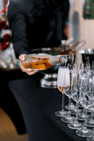 Bartender pouring champagne into a glass at a luxury event.の写真素材