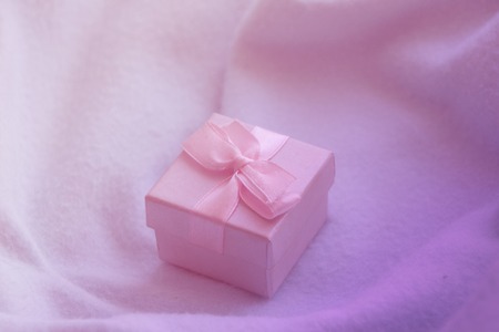 Little gift box with pink silky bow. Photo in soft pink and violet tonesの写真素材