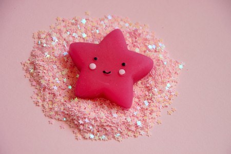 Cute smiling pink star lying in pink glittersの写真素材