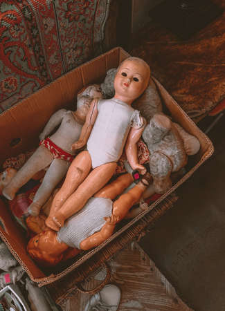 Vintage spooky dolls lying in box. Old style creepy toysの写真素材