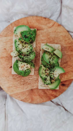 toast with avocado slices served on dry crispy bread. healthy food concept. Vertical mobile photo.