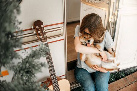 young woman holding and kissing her shiba inu dogの写真素材