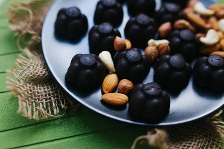 homemade sweets chocolates and nuts on a black plateの写真素材