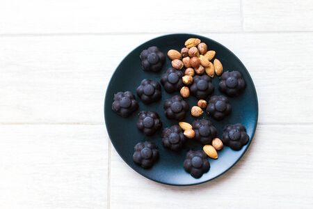 homemade sweets chocolates and nuts on a black plateの写真素材