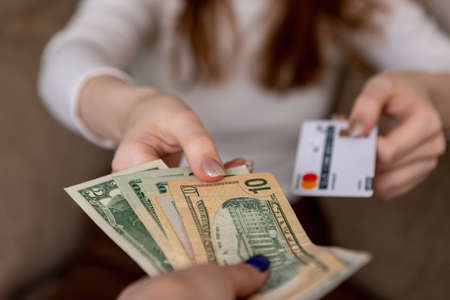A woman gives a bank card in exchange for cash dollars