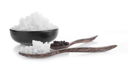 Pepper and salt on a wooden spoon isolated on white background.の写真素材