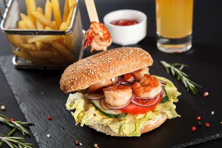 Burger with grilled shrimp with French fries and a glass of orange juiceの写真素材