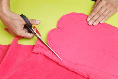 Woman's hands are cutting fabric with a tailors scissorsの写真素材