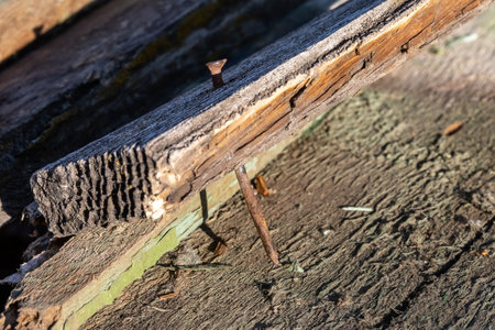 rusty nail sticking out of an old boardの写真素材