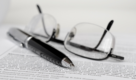 Pen and glasses on paperの写真素材
