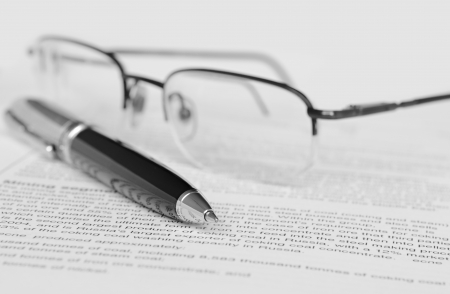 Pen and glasses on paperの写真素材