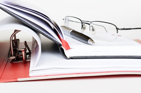 Pen and glasses on an opened diaryの写真素材