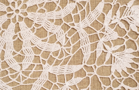 Canvas background with white crochet lace の写真素材