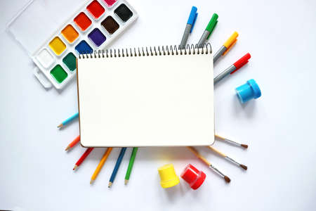School notebook and various stationery on white background