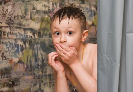 the boy looks out in the bathroom, bathes, in shock, surprised