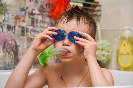 the boy looks out in the bathroom, bathes, in shock, surprisedの写真素材