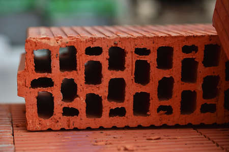 Red hollow wall brick. The pile of red hollow bricks lit. Material for construction and repair,...