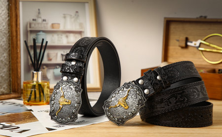 Fashionable black leather belt with metal buckle on wooden table.の写真素材