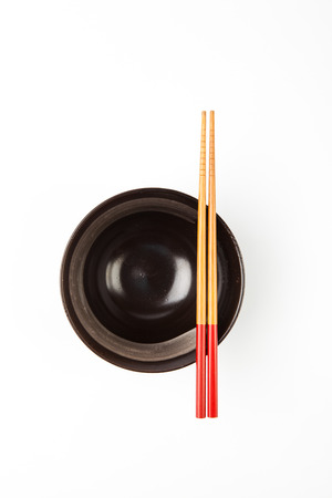 Chopsticks and black bowl isolated on white Backgroundの写真素材
