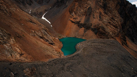 Emerald-colored lake in the mountain crater of the Aktru glacier valley. Altai republic.の写真素材