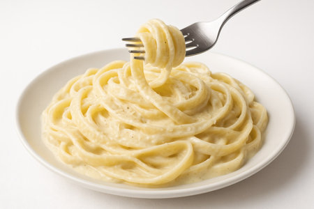 Fettuccine Alfredo with creamy parmesan sauce. Fettuccine alfredo pasta italian food isolated closeup fork twirlの素材