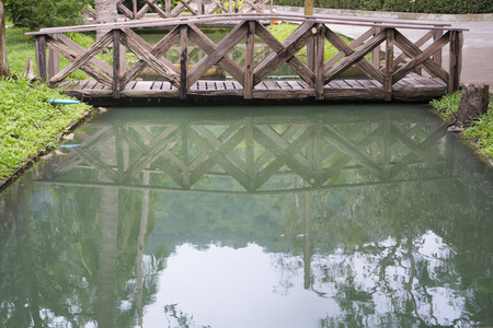 Perfect reflection of the small wooden bridge in the mirror smoothの写真素材