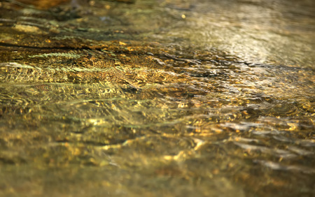 image of a swiftly moving stream in shades of goldの写真素材