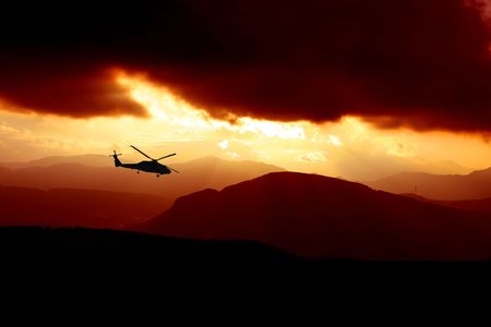 a rescue helicopter flys into a storm at sunsetの写真素材