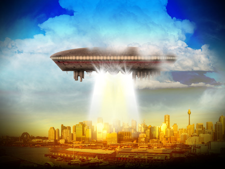An alien UFO over a city of skyscrappers shinning a beam of light.の写真素材