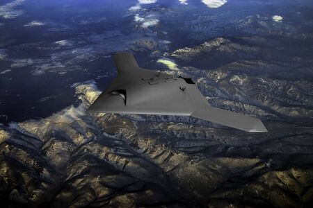A modern military drone flying high above the mountainsの写真素材