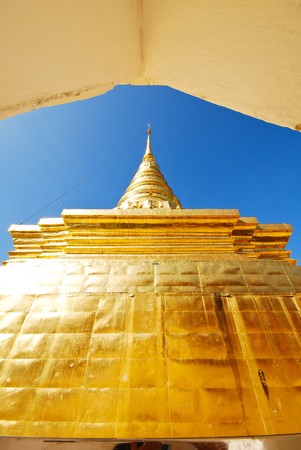 Golden temple stupa in Thailand against clear blue skyの写真素材