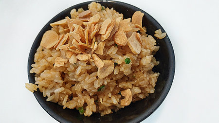Garlic fried rice in black bowl on white backgroundの写真素材