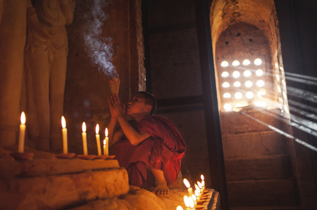 BAGAN, MYANMAR - Nov 6: Unidentified young Buddhism novice pray on Nov 6, 2015 in Bagan. Buddhism is predominantly of the Theravada tradition, practised by 89% of the population.のeditorial素材