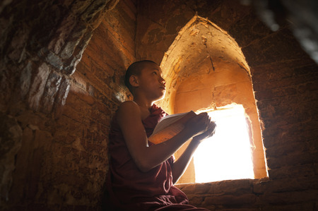 BAGAN, MYANMAR - Nov 6: Unidentified young Buddhism novice pray on Nov 6, 2015 in Bagan. Buddhism is predominantly of the Theravada tradition, practised by 89% of the population.のeditorial素材