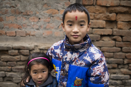 BHAKTAPUR, NEPAL, November 15: Portrait of young Nepalese boy and girl with red dot on his face posing at the camera, Nepal 2015.のeditorial素材