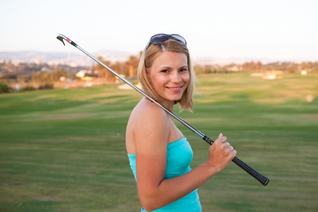 Portrait of an elegant woman playing golf on a greenの写真素材
