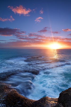 Image of a sunrise on the rocks at the ocean in South Africa の写真素材