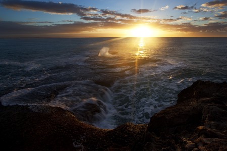 Image of a sunrise on the rocks at the ocean in South Africa の写真素材