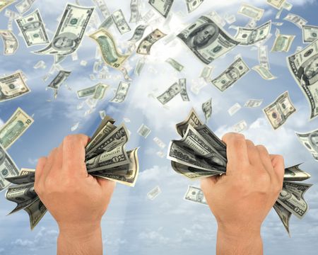 Wealth idea in a metaphor of rain of dollars. The hand holds some dollars.の写真素材