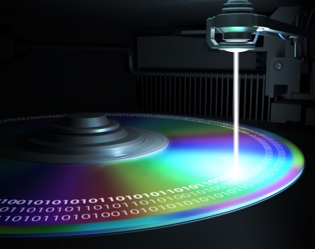 The laser writes information to disk (CD, DVD, Blu-Ray). Concept of technology and future. の写真素材