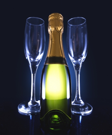 A bottle of champagne with 2 glasses on the side.の写真素材
