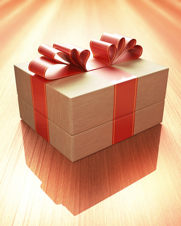 Gift with red ribbon tied up, on a wooden table. Clipping path included.の写真素材