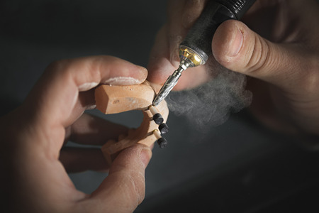 Dental prosthesis, artificial tooth, prosthetic, hands working on the denture, false teeth.の写真素材