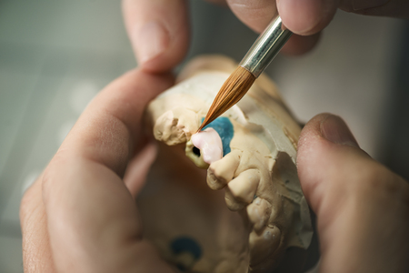 Dental prosthesis, artificial tooth, prosthetic, hands working on the denture, false teeth.の写真素材