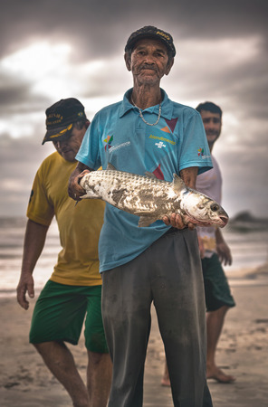 Ilha Do Mel, ParanÃ¡, Brazil - June 3, 2017: Fisherman native to Ilha do Mel (Honey Island), holding a mullet.のeditorial素材